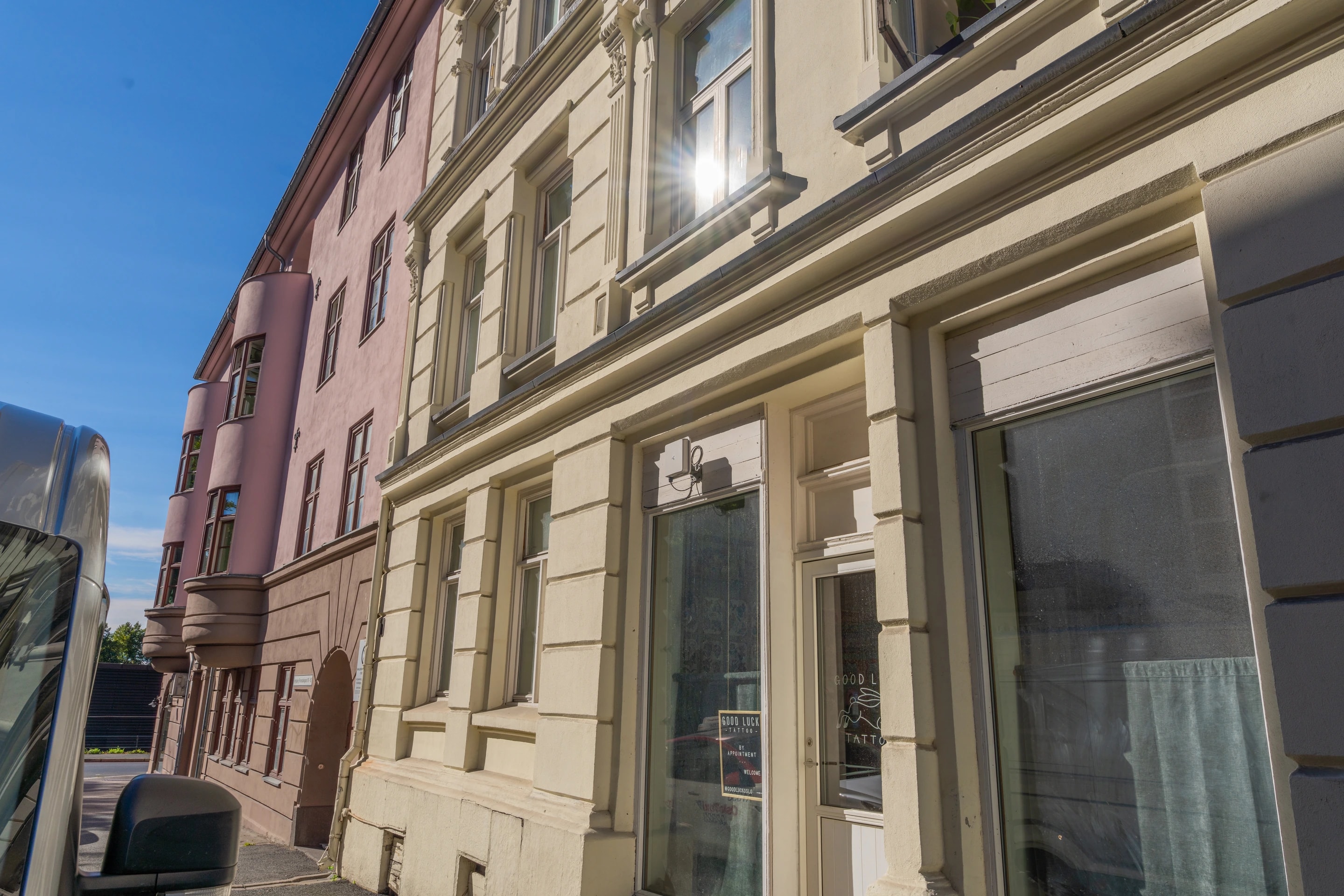 Pussdetaljer og vinduer på en lys bygårdsfasade