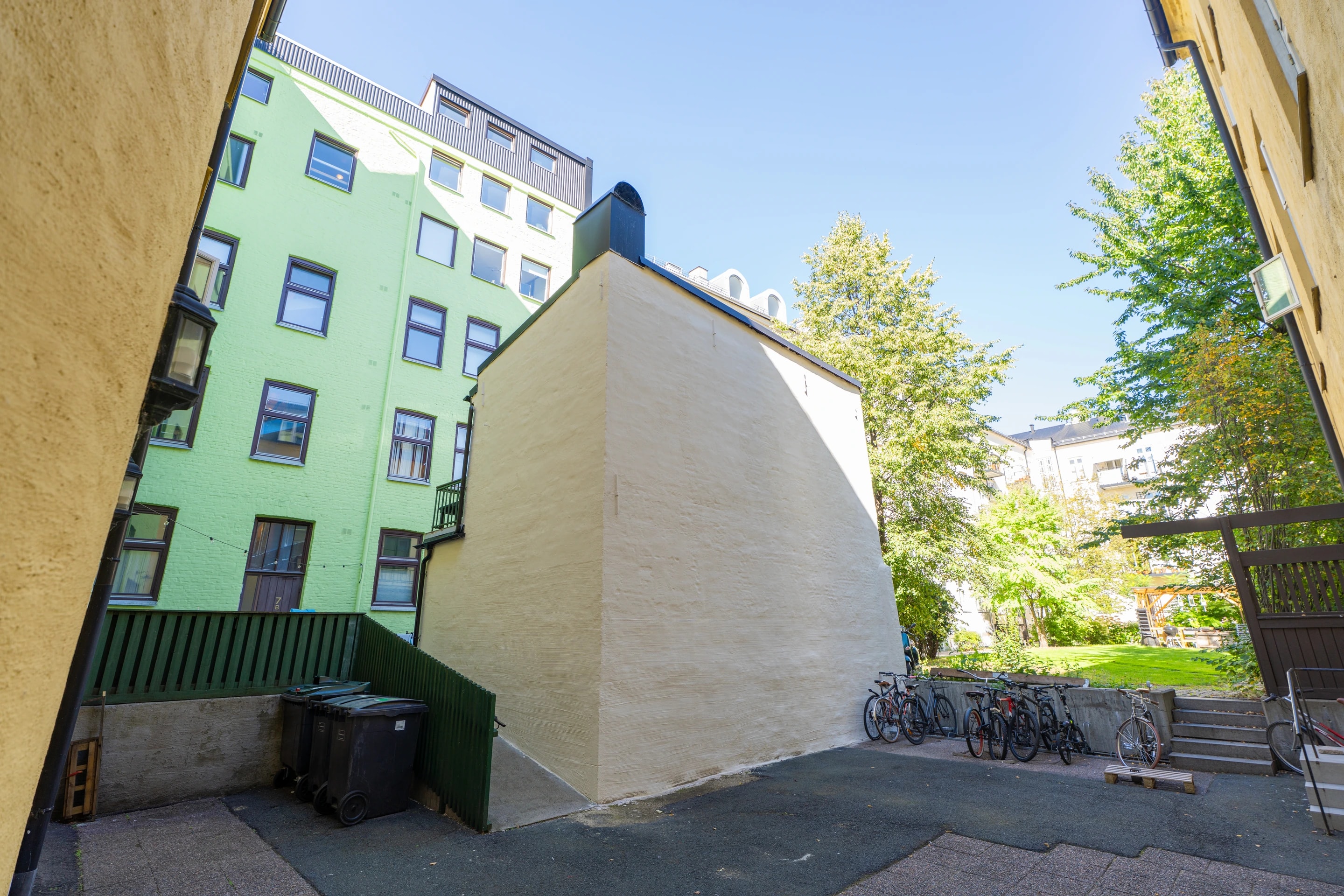 Trang bakgård med sykler og murte vegger