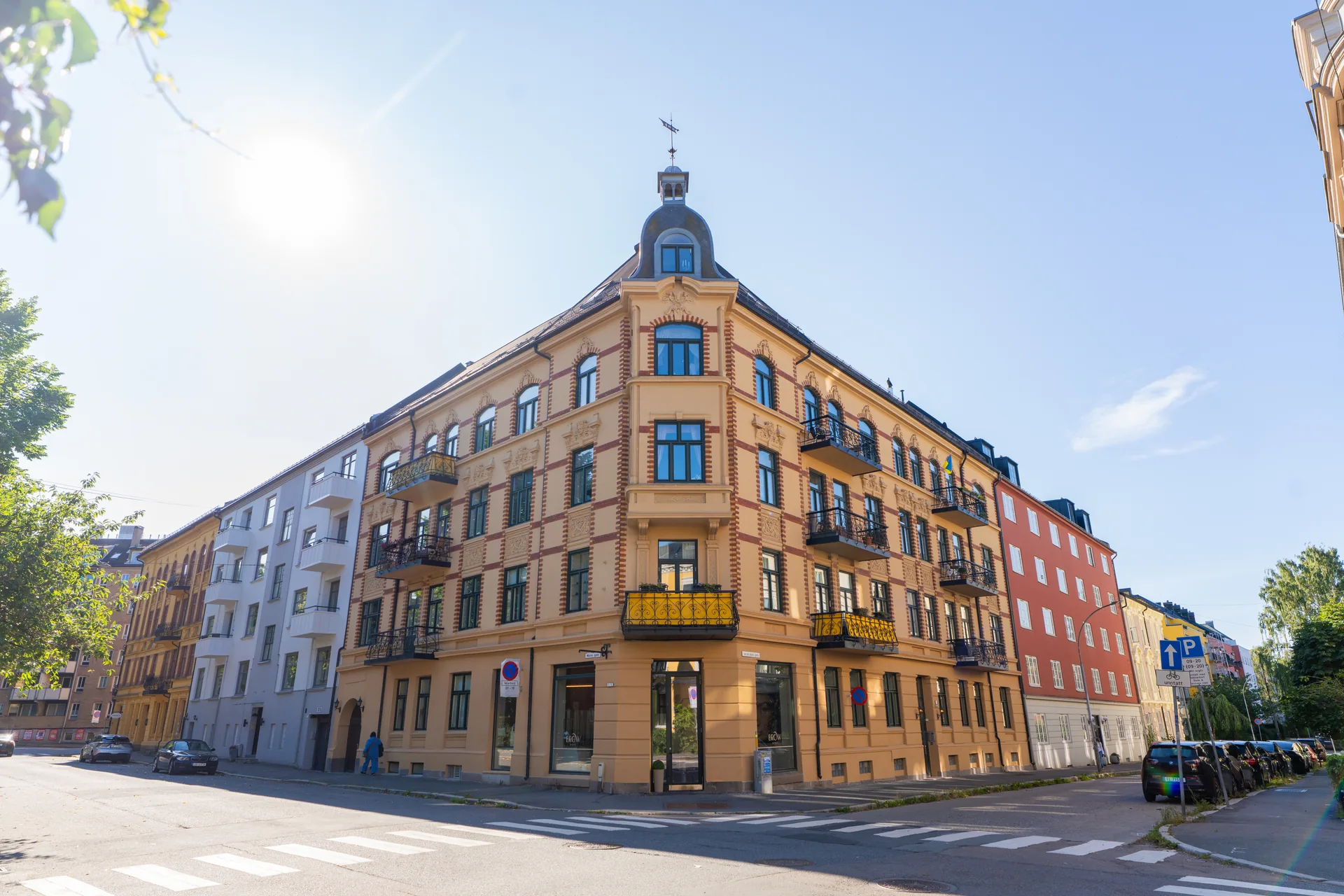 Gul hjørnegård med balkonger og tårn