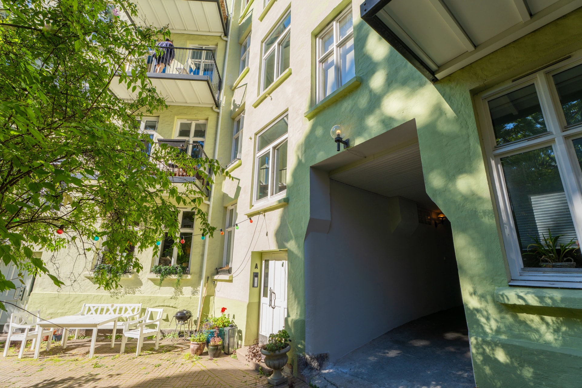 Inngang og grønt uteareal i en bakgård